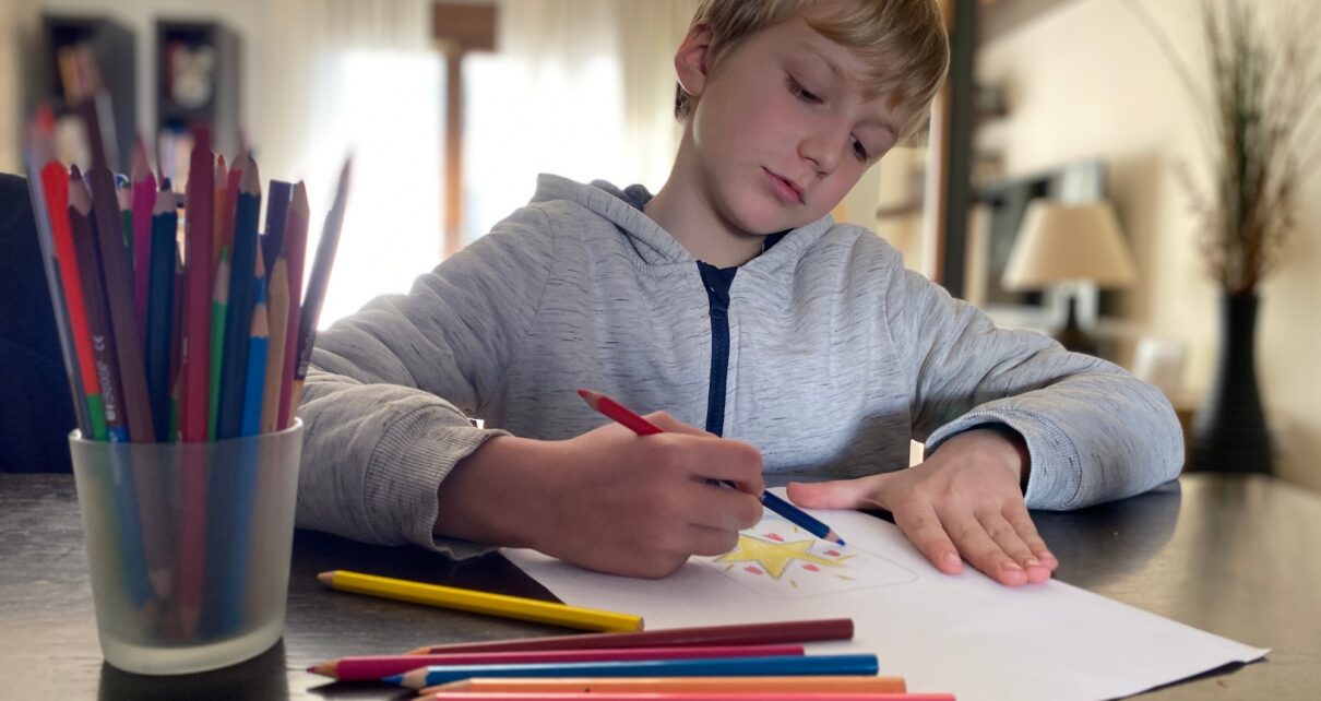 Boy, 9 years old drawing with color pencils