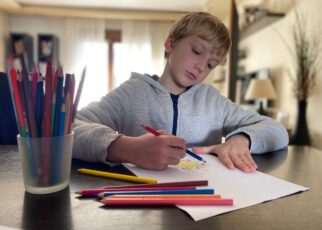 Boy, 9 years old drawing with color pencils