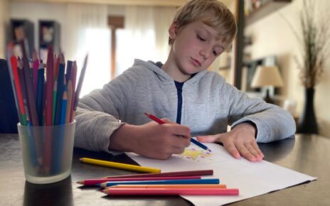 Boy, 9 years old drawing with color pencils