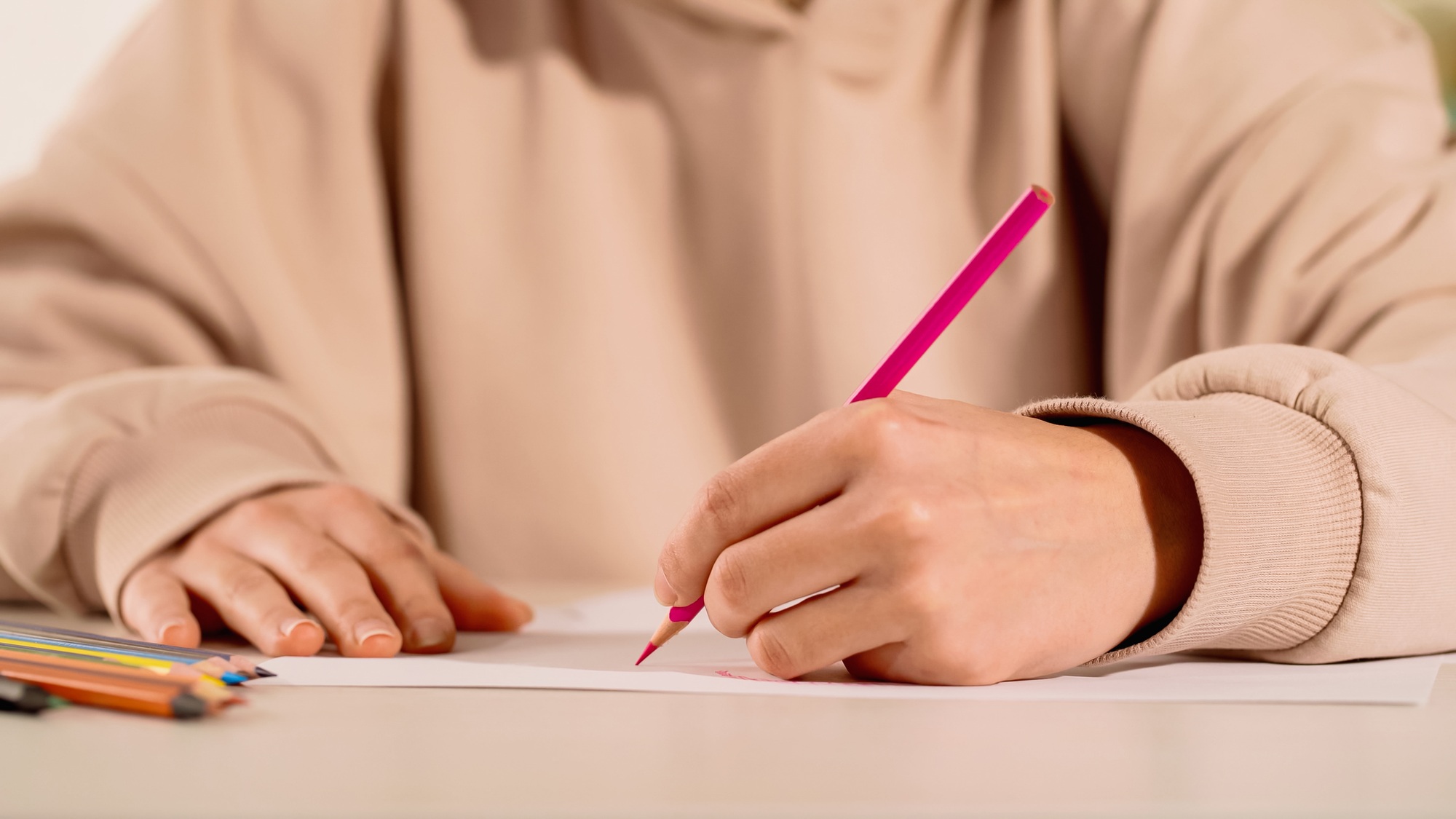 Cropped view of woman drawing with color pencil at home