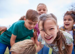 Portrait Of Children On Outdoor Activity Camping Trip Having Fun Playing Game Together