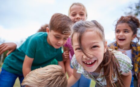 Portrait Of Children On Outdoor Activity Camping Trip Having Fun Playing Game Together