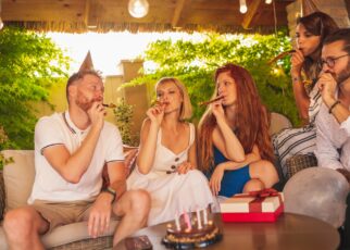 Friends blowing party whistles at birthday party