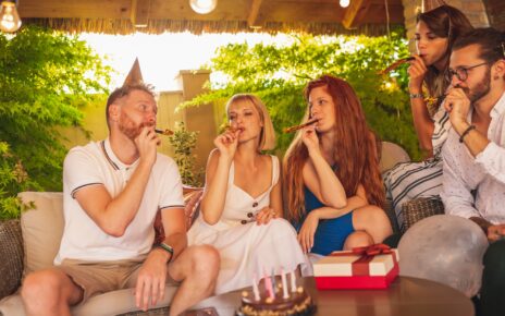 Friends blowing party whistles at birthday party