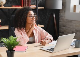 Schoolgirl writing essay, poem, novel with imagination, doing homework assignment using laptop