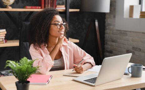 Schoolgirl writing essay, poem, novel with imagination, doing homework assignment using laptop