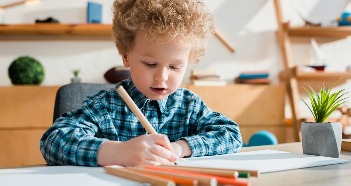 selective focus of kid drawing at desk