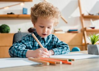 selective focus of kid drawing at desk