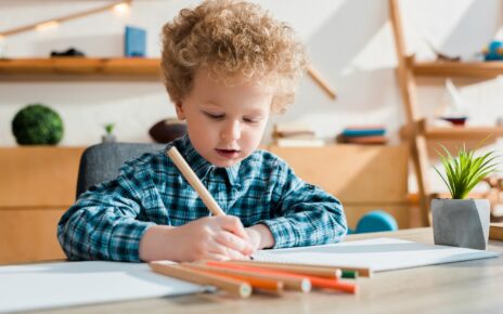 selective focus of kid drawing at desk