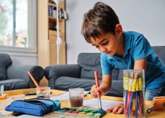young kid playing with colors and drawing